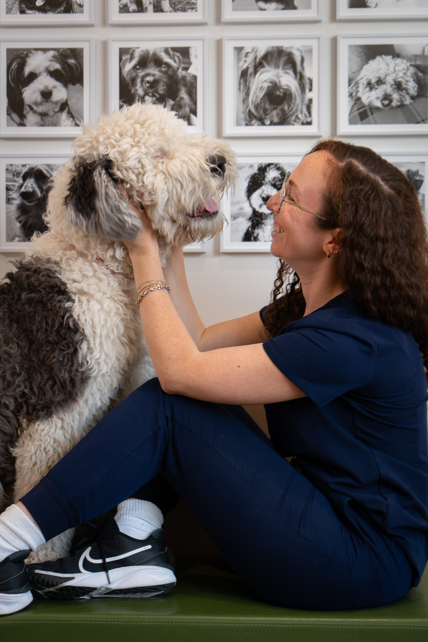 A veterinary team member sitting with and cuddling a dog