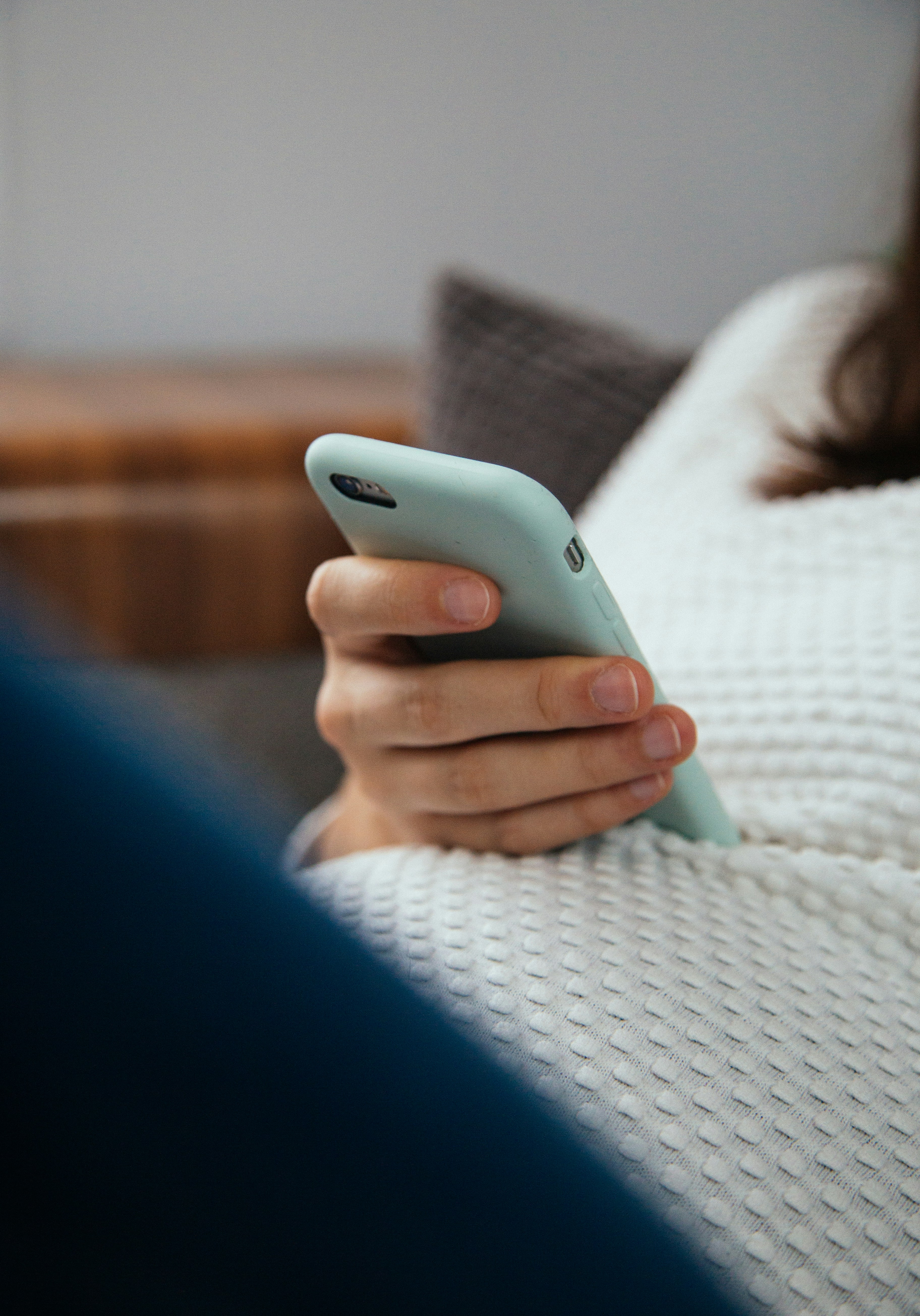 A person using a mobile phone while sitting at home